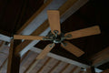 Five-blade wooden ceiling fan on a timber ceiling