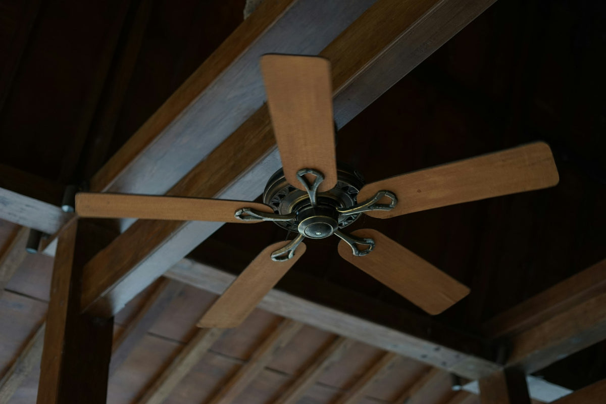 Five-blade wooden ceiling fan on a timber ceiling